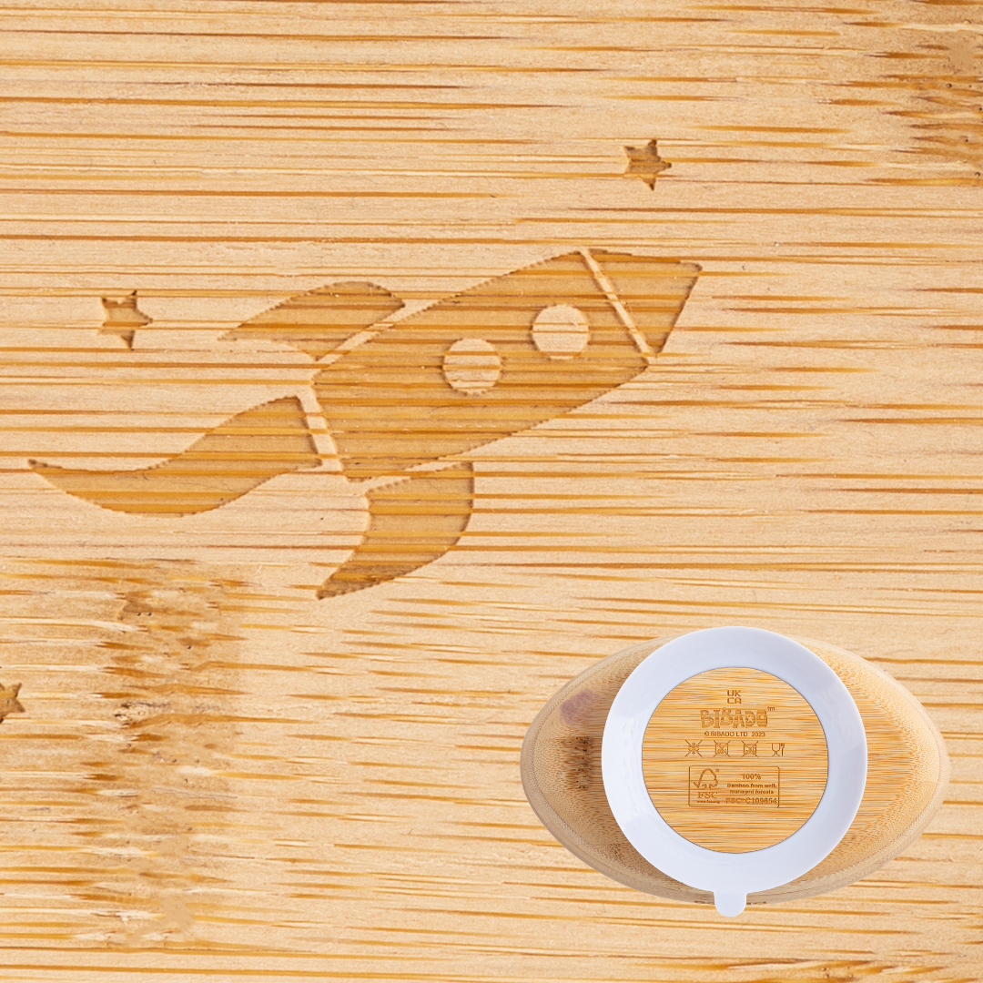 Natural bamboo suction bowl with a rocket and stars engraving, featuring a white silicone base. - Product image