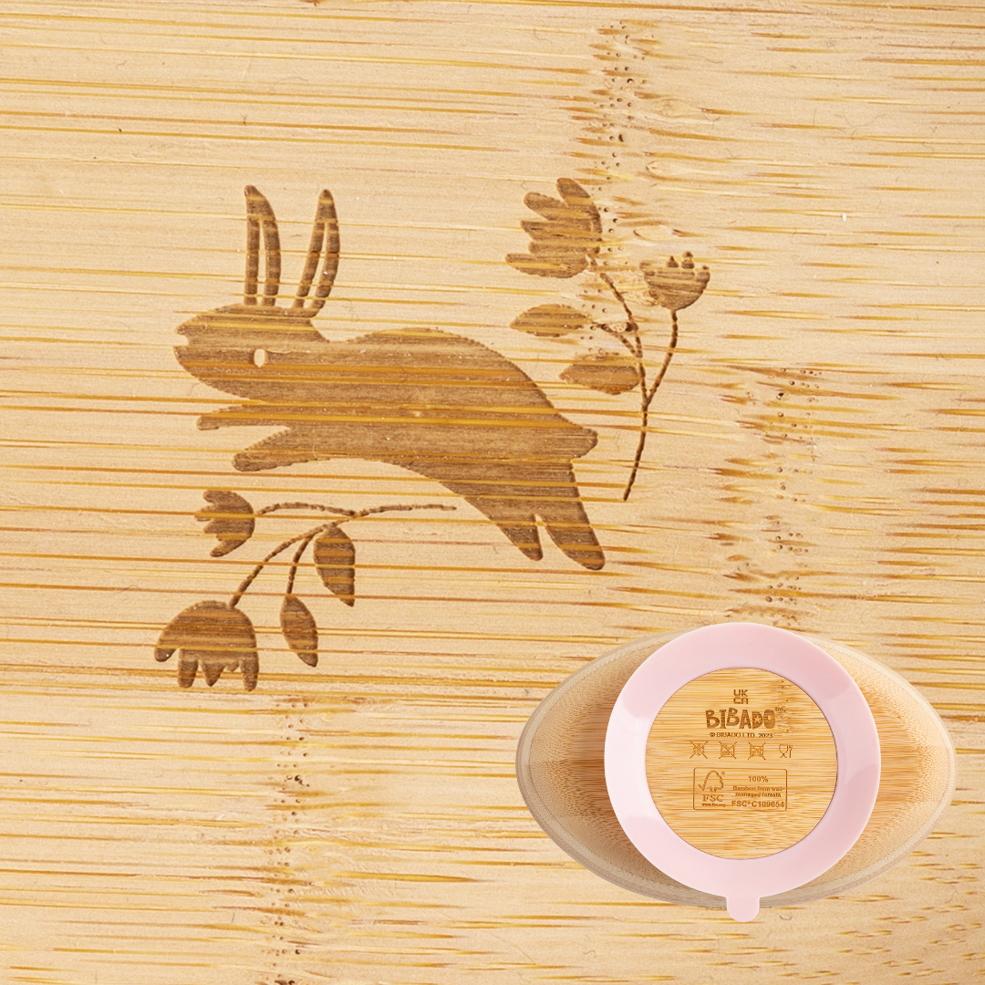 Natural bamboo suction bowl with a pink silicone base, featuring a laser-engraved bunny and floral design. - Product image