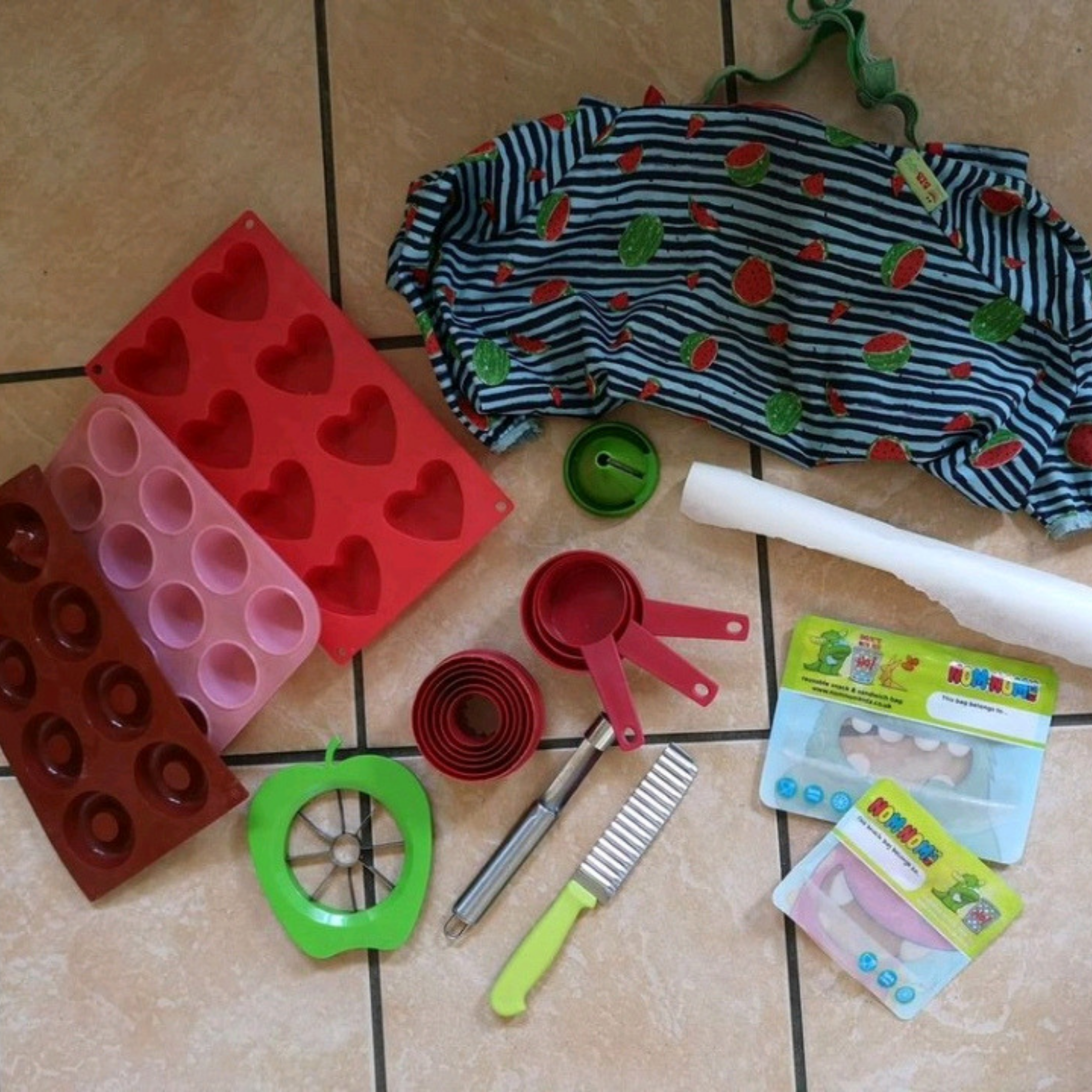 Weaning essentials: colourful silicone moulds, a watermelon bib, and baby food tools.