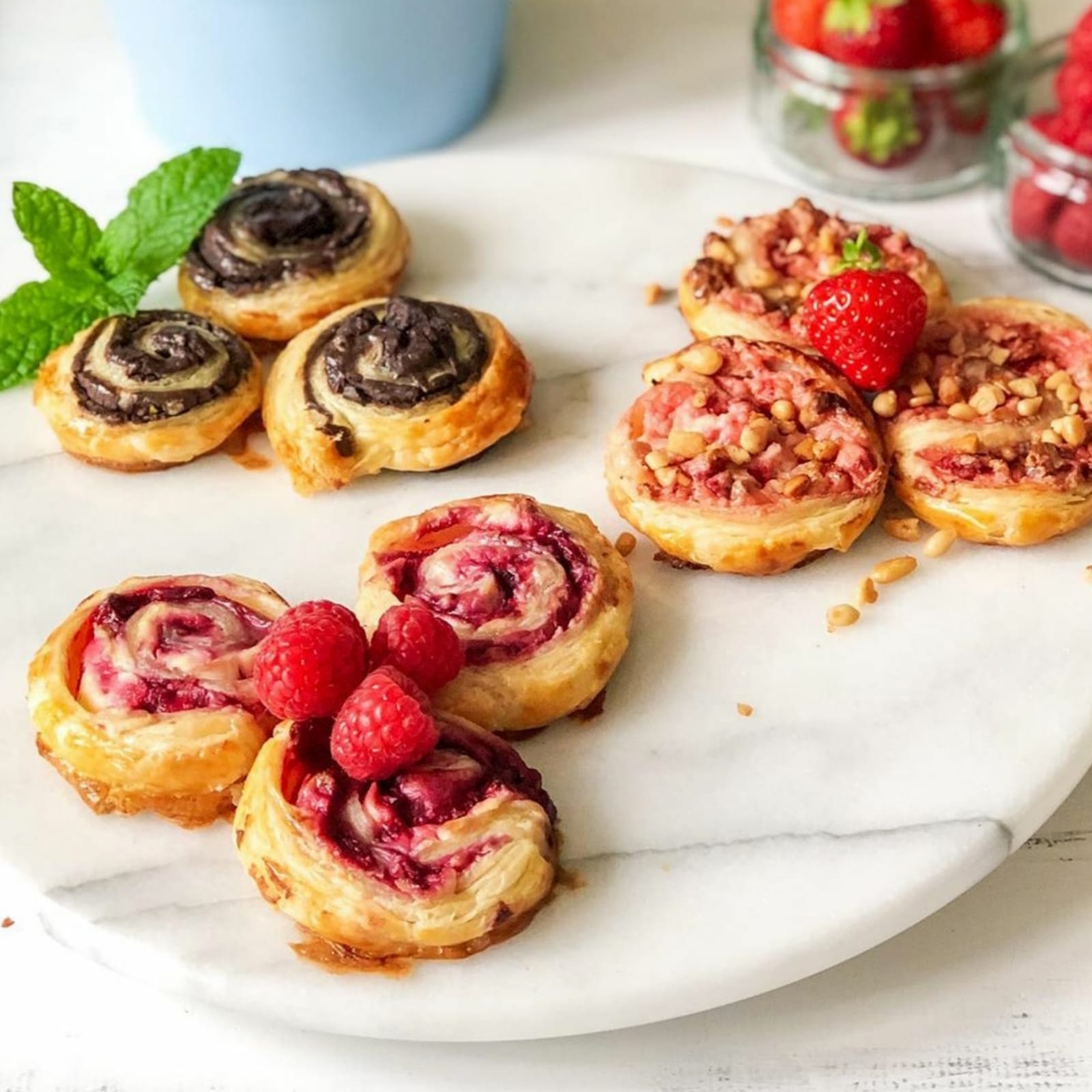 Assorted ice cream pinwheels: chocolate, strawberry, and raspberry, on a marble board.