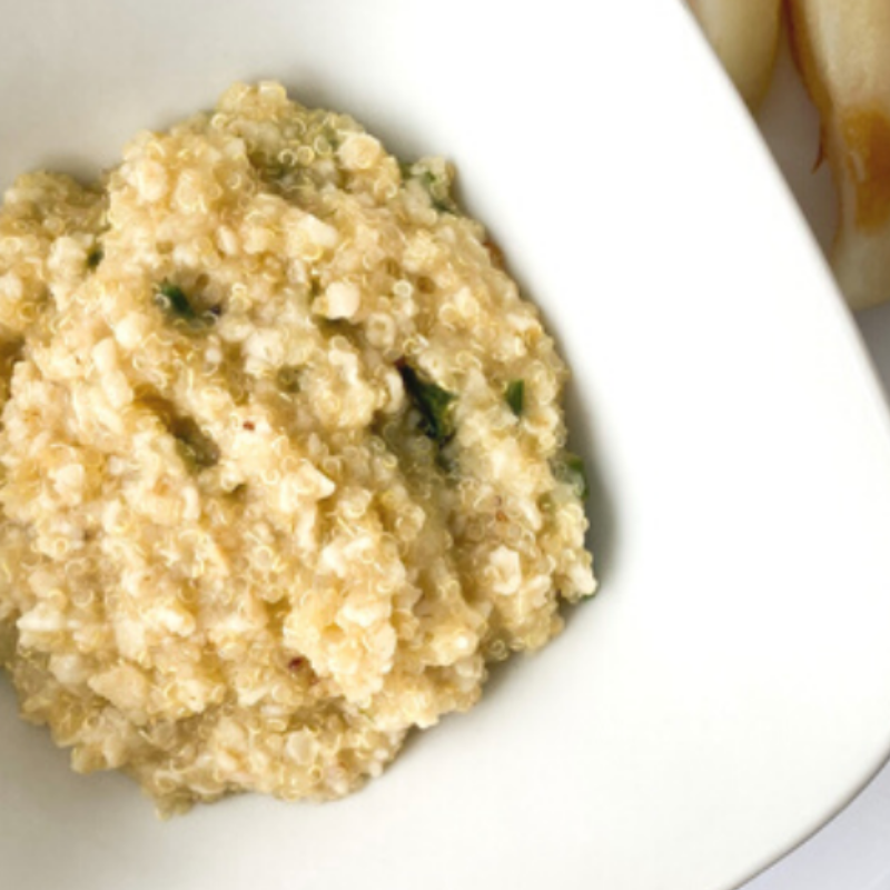 Creamy courgette bread porridge with quinoa in a white bowl.