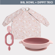 Pink long-sleeved weaning bib with bunny and floral print, matching silicone suction bowl, and soft Dippit spoon.