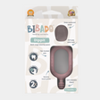 Pink Dippit™ multi-stage baby spoon and textured dipper in packaging, showing two-handed grip and deep contoured spoon.