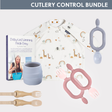 White long-sleeve bib with safari animals, gray silicone cup, pink and beige toddler forks, gray teether, and a weaning book.
