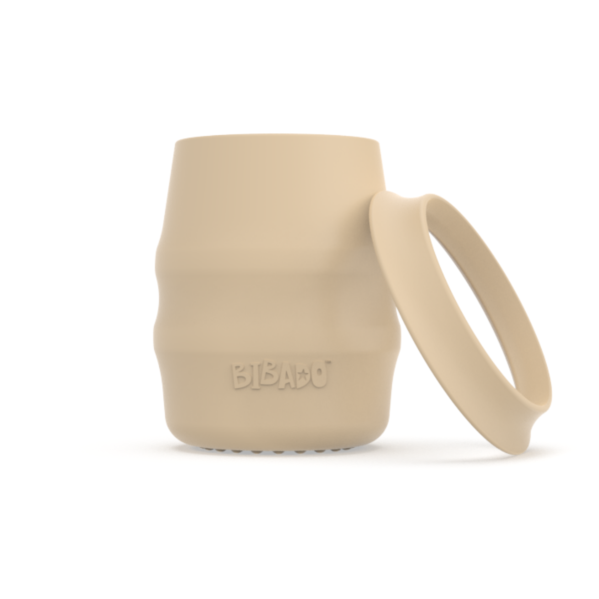 A beige silicone baby drinking cup with a removable silicone skirted base propped against it, shown on a clean white background.  - Product image