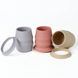 Three silicone open cups in blue, pink, and beige, shown with their matching silicone skirts on a clean white background.