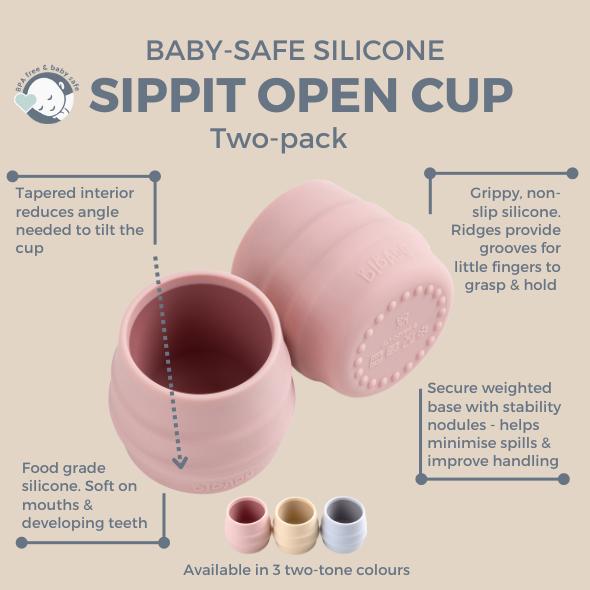 Two pink silicone Sippit open training cups with ridged sides and weighted bases. - Product image
