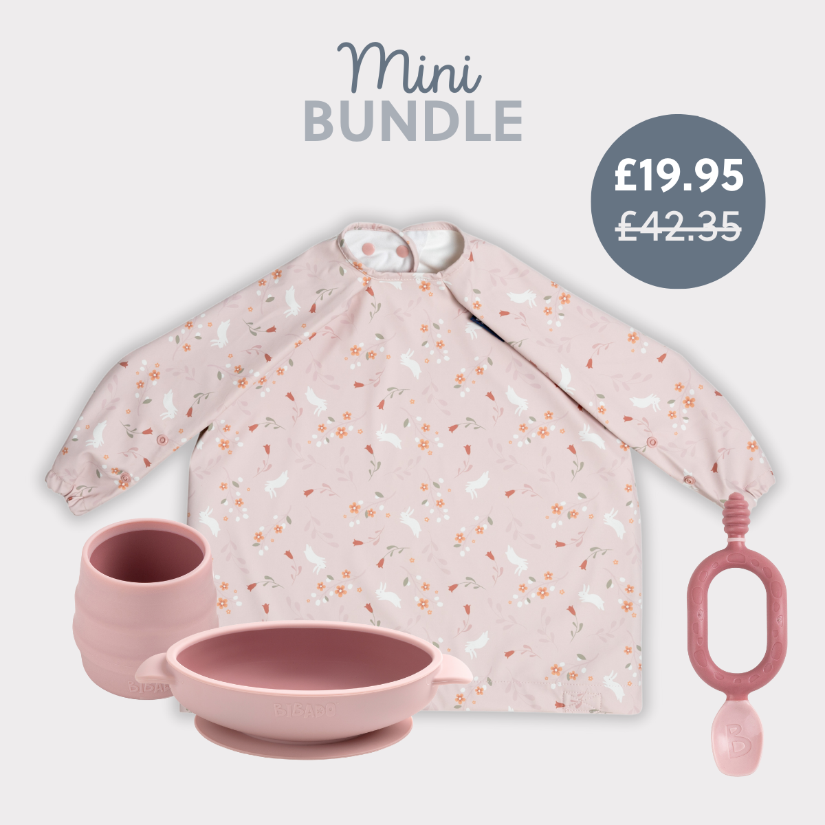 Pink silicone baby feeding set with suction bowl, cup, spoon, and long-sleeved bib with bunny and carrot print. - Product image