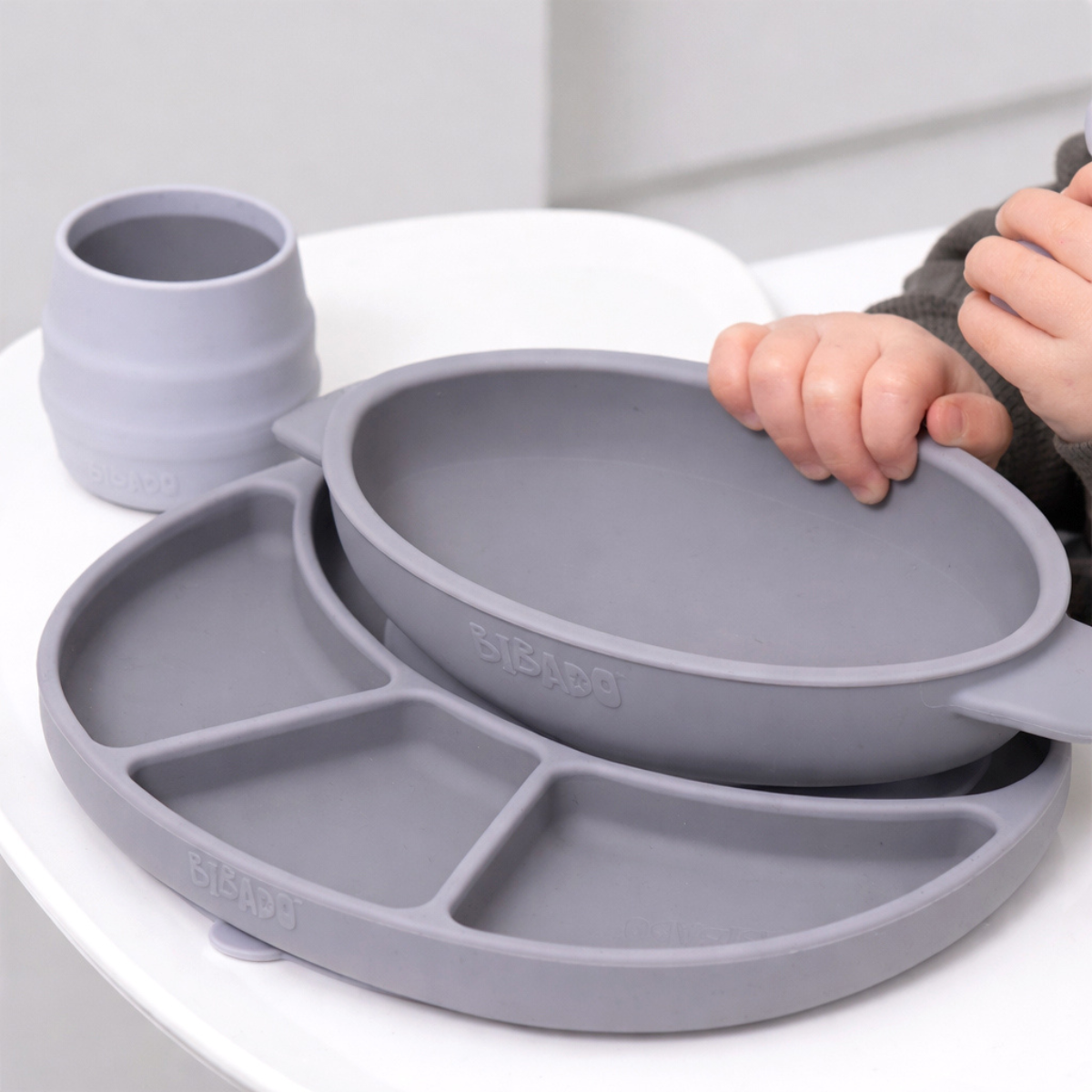 Mist silicone plate with divided sections, with matching bowl and a Sippit cup on a white high chair. - Product image