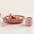 Pink silicone suction bowl with strawberries, matching training cup, and baby spoon.
